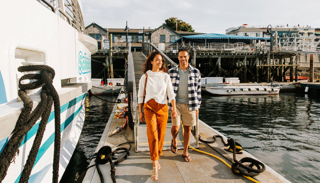 A couple walks to board a catamaran with the Bar Harbor Whale Watch Company.