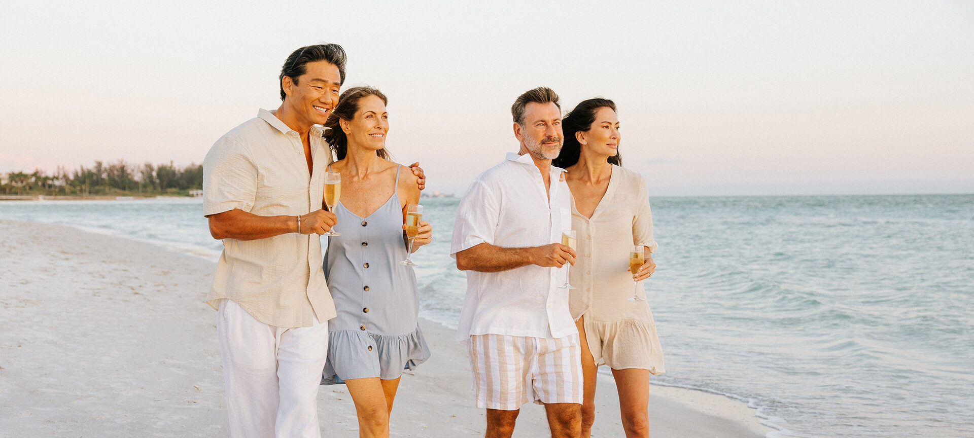 Two couples walk along Longboat Key beach.