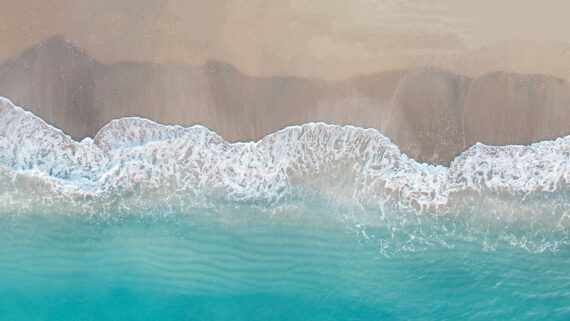 Aerial view of ocean waves gently lapping Jupiter Beach, Florida.