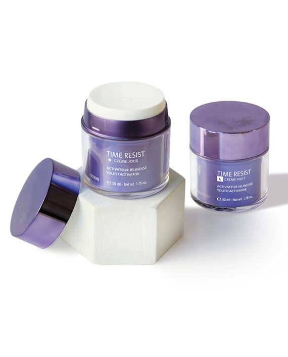 Three purple cosmetic jars labeled Time Resist are displayed on and beside a white hexagonal pedestal; one jar is open, revealing white cream inside. The scene has a clean, minimalistic look.